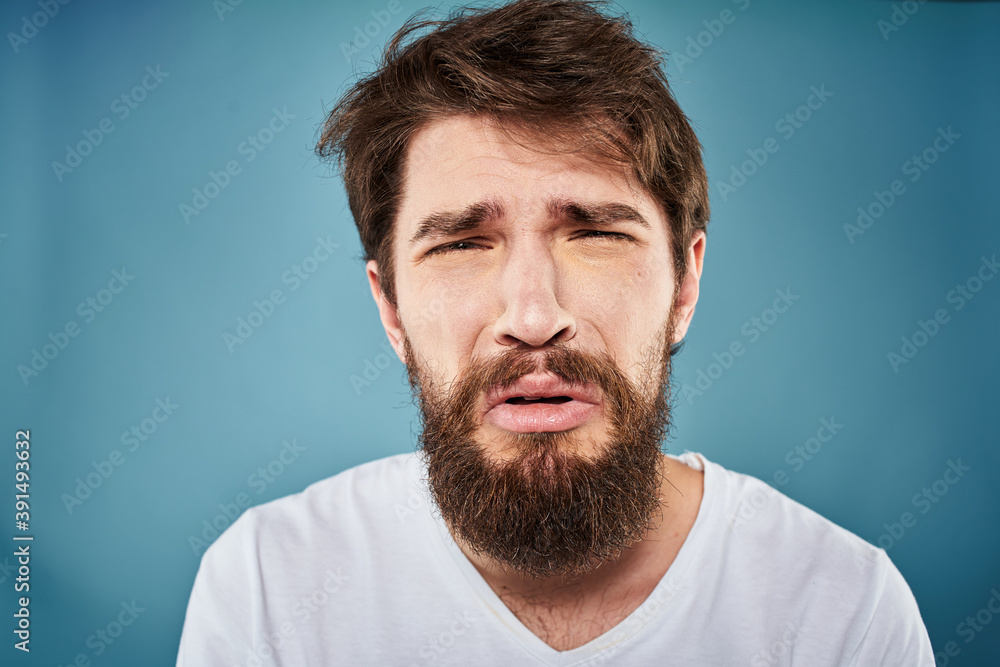 Man in white t-shirt lifestyle studio emotions facial expression blue isolated background Man in white t-shirt lifestyle studio emotions facial expression blue isolated background