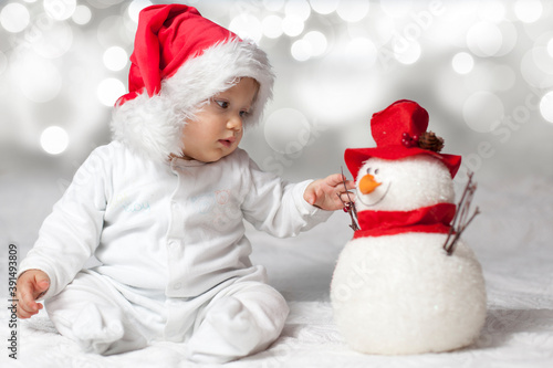 Baby with red santa hat and snowman