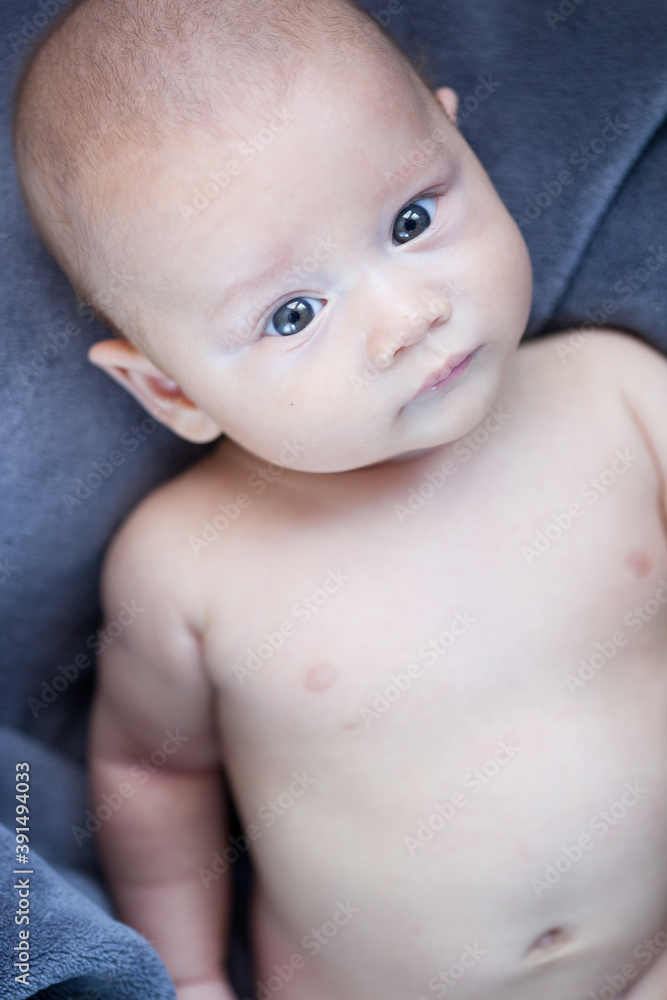 Baby with blue eyes portrait lying on bed Baby with blue eyes portrait lying on bed