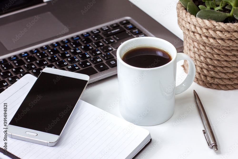 Desktop at home laptop open Notepad with pen coffee Cup on white table Desktop at home laptop open Notepad with pen coffee Cup on white table
