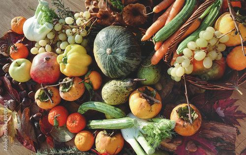 typical autumn fruits and vegetables in a colorful composition on wooden table