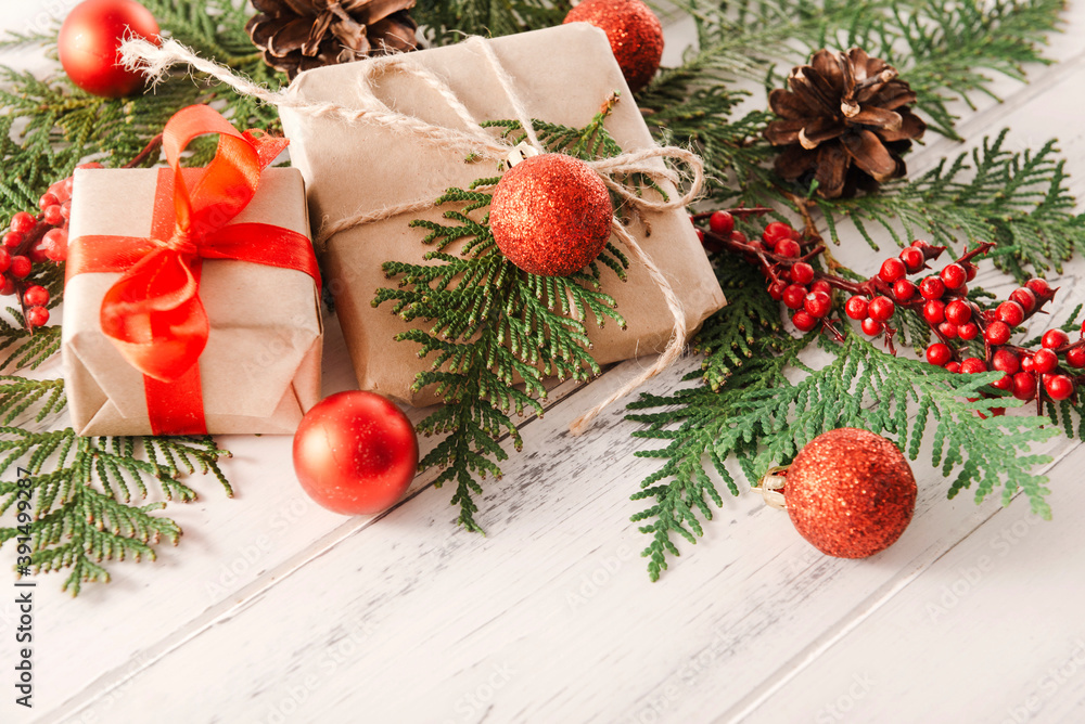 Christmas gift with red ribbon and fir branches, red Christmas balls on white wooden top view Christmas gift with red ribbon and fir branches, red Christmas balls on white wooden top view