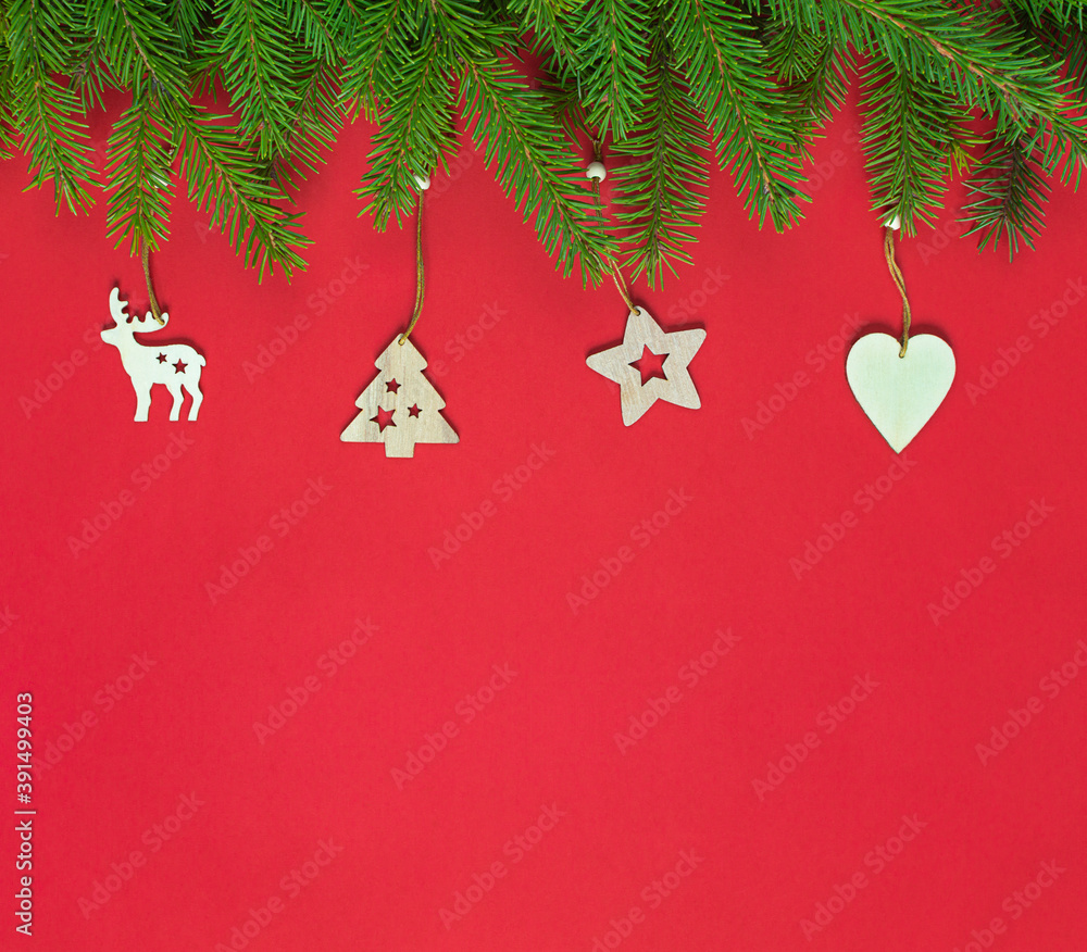 Christmas border with fir branches and wooden Christmas tree toys on red with copy space. new year card Christmas border with fir branches and wooden Christmas tree toys on red with copy space. new year card