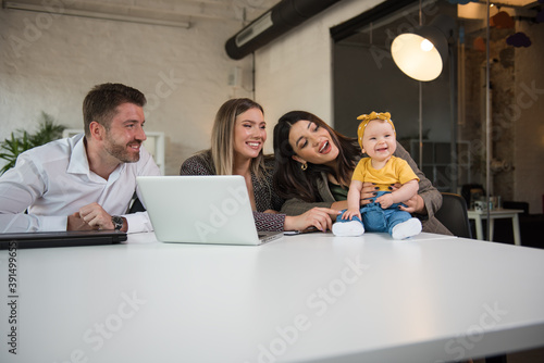 Single mom heaving fun in her office with her female colleague and her little baby girl © Daniel