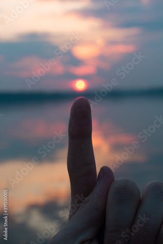 Sunset sun over the water. Red evening sun on blurred background