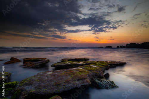 Calm ocean long exposure. Stones in mysterious mist of the sea waves. Concept of nature background. Sunset scenery background. Mengening beach  Bali  Indonesia.