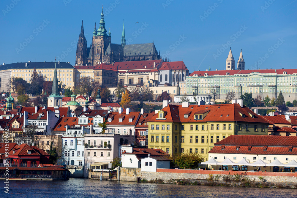 Obraz premium Autumn colorful Prague Lesser Town with gothic Castle above River Vltava in the sunny Day, Czech Republic