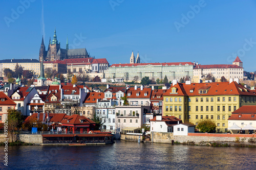 Autumn colorful Prague Lesser Town with gothic Castle above River Vltava in the sunny Day, Czech Republic