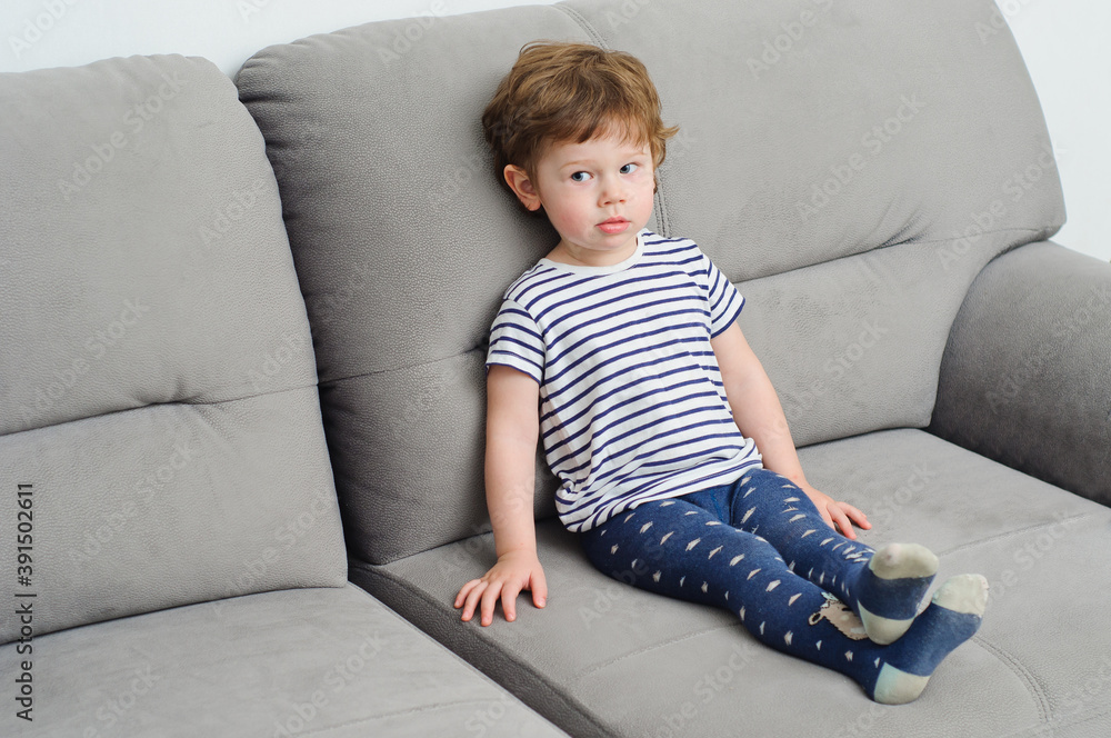 little boy with red hair at home, playing on the couch. little boy with red hair at home, playing on the couch.