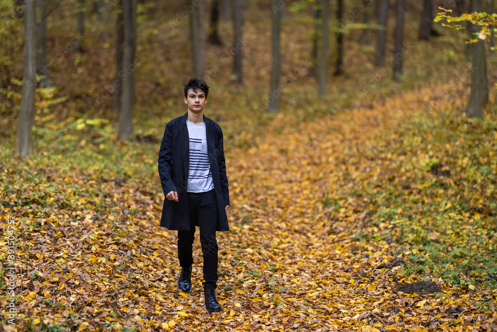 Portrait with a handsome young man in autumn forest, fashion concept.
