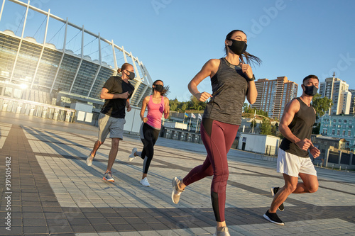Young multi race sportive people in protective masks