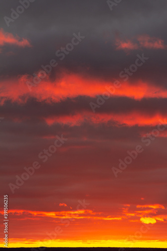 Wonderful November sunset with bright red-pink clouds on a dark gray-blue sky