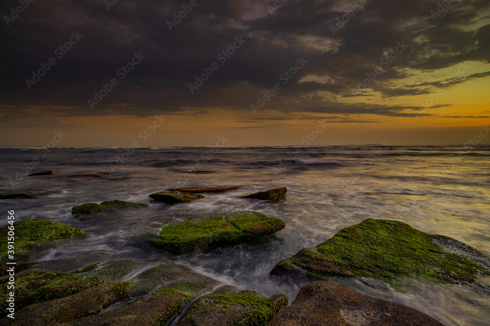 Amazing seascape with motion waves. Waterscape background. Moving water. Nature concept. Sunset scenery background. Long exposure. Mengening beach, Bali, Indonesia.