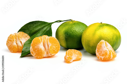 Fotografia Ripe green and yellow tangerines and orange tangerine slices isolated on white background