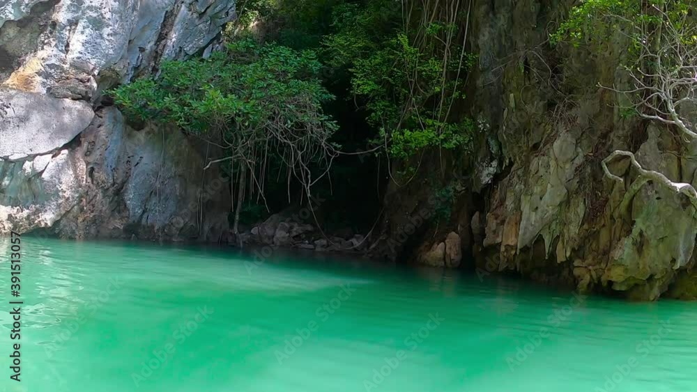 Amazing green water in the lagoon. Approaching the cave between the rocks. Calm water of the Bay. Vines hanging from trees. Amazing green water in the lagoon. Approaching the cave between the rocks. Calm water of the Bay. Vines hanging from trees.