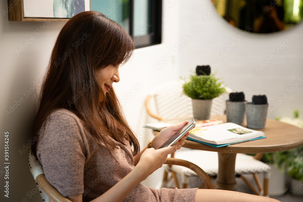 Asian business woman working and typing on phone.