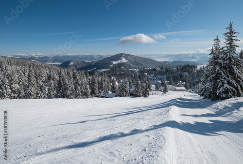 Snow covered mountain ski resort slope . Magnificent sunny day on picturesque alpine resort, Dragobrat, Ukraine, Carpathian Mountains. People unrecognizable.