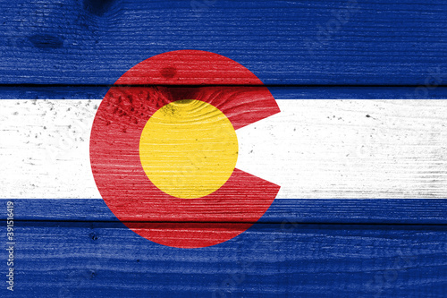 colorado flag painted on old wood plank background. Brushed natural light knotted wooden board texture. Wooden texture background flag of colorado