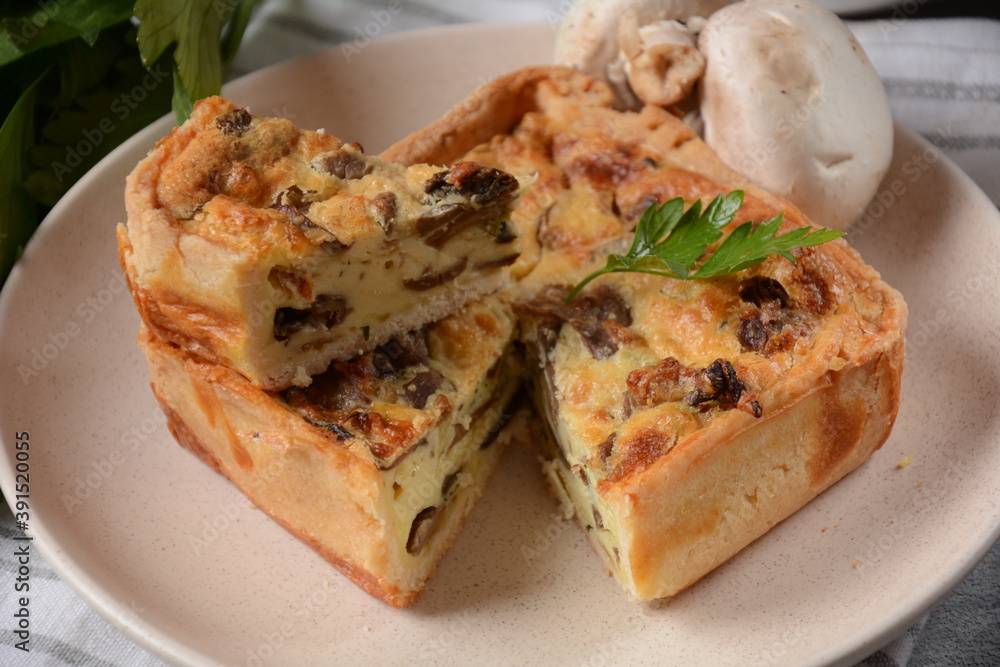 Homemade quiche or pie with  broccoli, seasonings, champignons and cheese on a gray background.