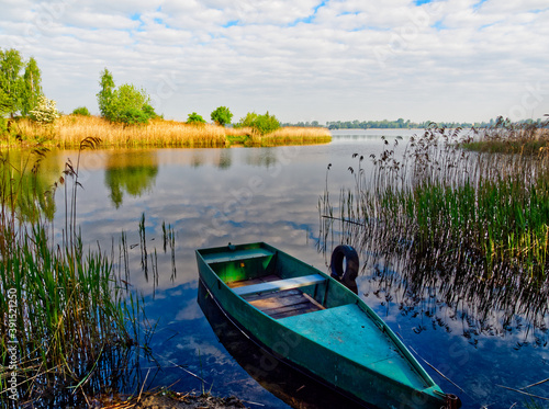 Fototapeta Naklejka Na Ścianę i Meble -  Small boat against the lake against the sky.