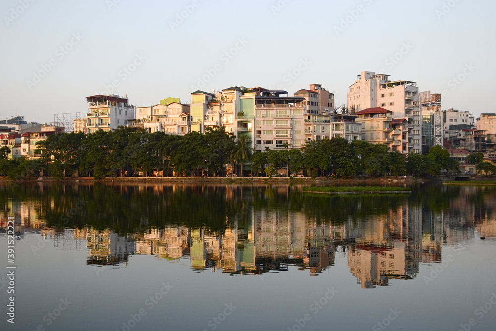 Public city park near Tay lake in the downtown district of Hanoi, Vietnam. Residential houses reflected in water