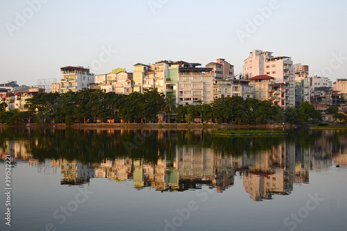 Public city park near Tay lake in the downtown district of Hanoi  Vietnam. Residential houses reflected in water