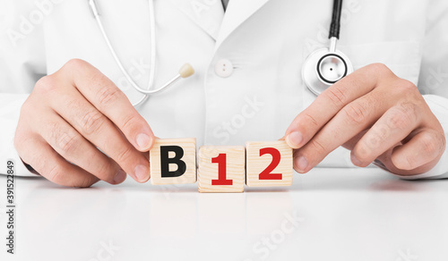 Doctor holds wooden cubes in his hands with text B12 photo