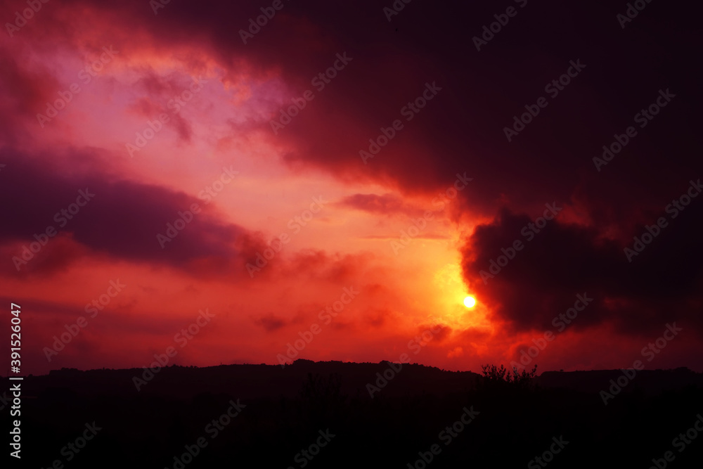Red sunset with the sun behind the clouds