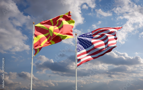 Beautiful national state flags of North Macedonia and USA together at the sky background. 3D artwork concept.