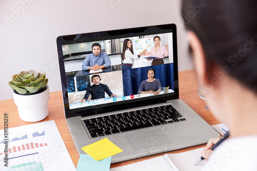 Businessman and businesswoman analysis financial chart with videoconference online meeting. Hand of businesswomen using laptop meeting with diverse colleagues. Covid-19 working from home.