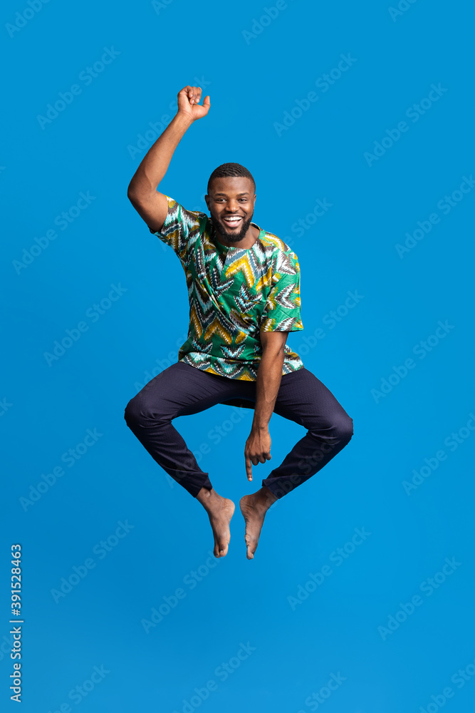 Funny black man in african costume jumping in the air Stock Photo | Adobe  Stock