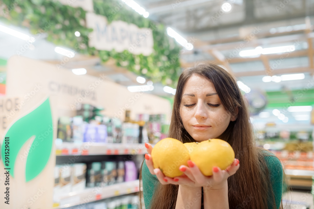 Young woman holds fragrant tangerines in her hands
Young woman holds fragrant tangerines in her hands