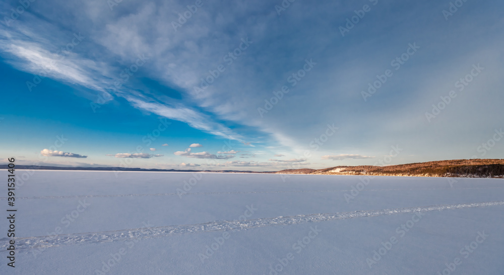 Frozen lake and sky with clouds in winter
