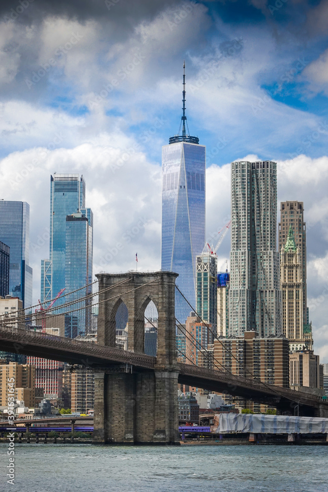 View from Brooklyn Bridge to Manhattan in New York during sunny day with blue sky and white clouds View from Brooklyn Bridge to Manhattan in New York during sunny day with blue sky and white clouds