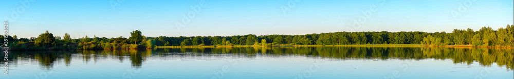 Panorama of the lake with a forest on the opposite shore Panorama of the lake with a forest on the opposite shore