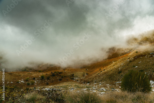 Scenic landscape view with mountain slope in low lying cloud
