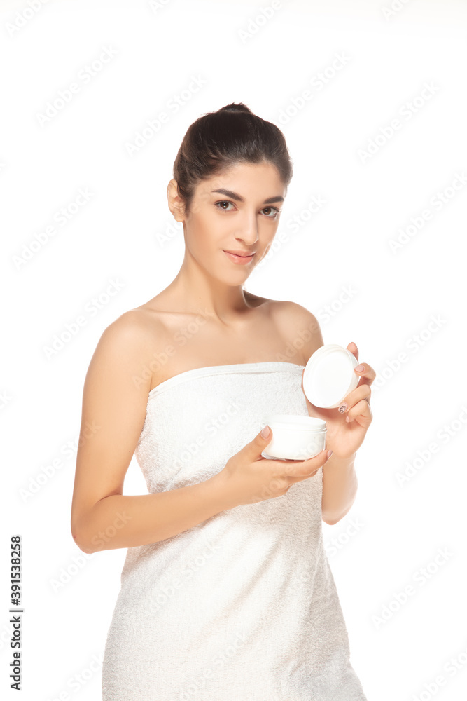Moisturizer. Beautiful female model isolated on white background. Beauty, cosmetics, spa, depilation, diet and treatment, fitness concept. Fit and sportive, sensual body with well-kept skin in towel. Moisturizer. Beautiful female model isolated on white background. Beauty, cosmetics, spa, depilation, diet and treatment, fitness concept. Fit and sportive, sensual body with well-kept skin in towel.