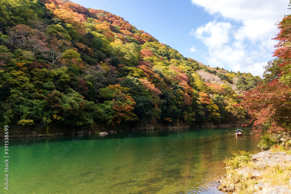 Arashiyama in autumn season along the river. Beautiful place to experience nature in Kyoto, Japan.