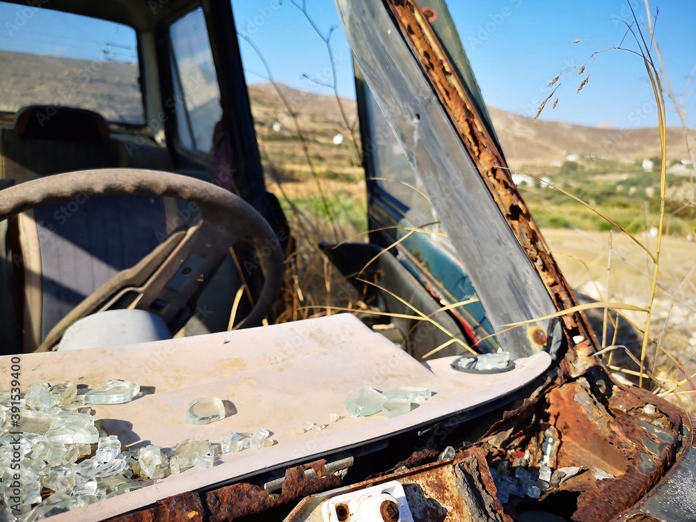 rusty old car before mountain and desert panorama opn the island of Naxos, Greece