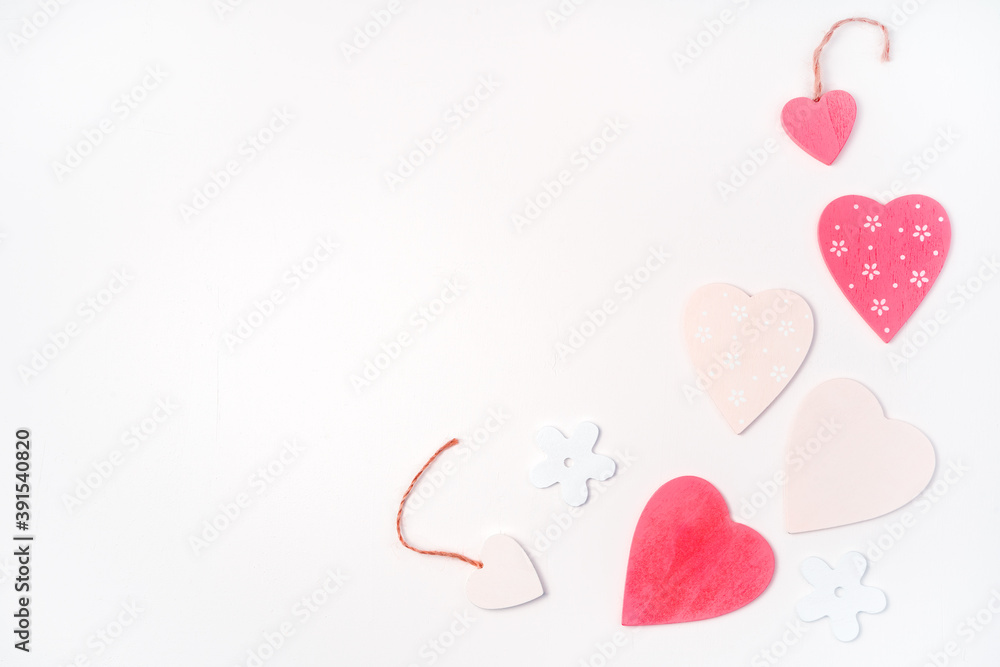 Pink and white hearts of different sizes are laid out on a light background in the right part of the frame. Top view with space to copy. The Concept Of Valentine's Day.