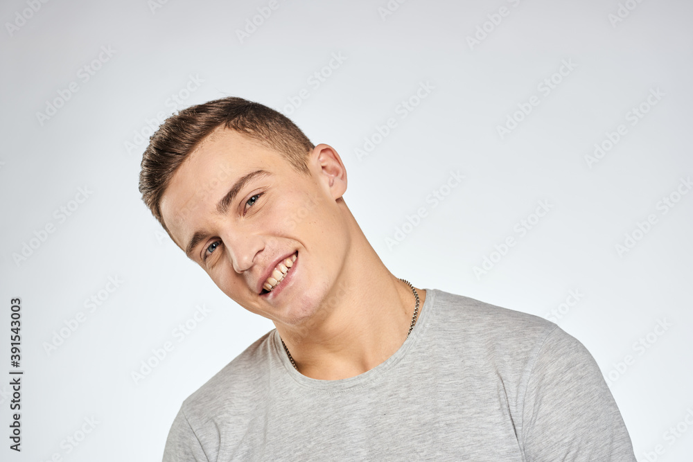 Handsome man in gray t-shirt cropped view of emotion Studio Model Handsome man in gray t-shirt cropped view of emotion Studio Model
