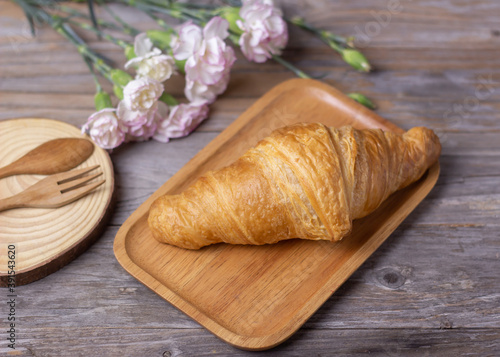 tasty croissants in a wood plate on dark wooden table, closeup. French pastry