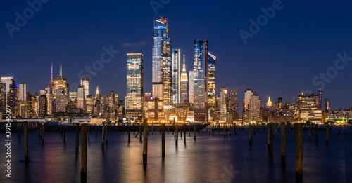 New York City evening panoramic of Manhattan Midtown West skyline with illuminated Hudson Yards skyscrapers from the Hudson River. NYC, USA