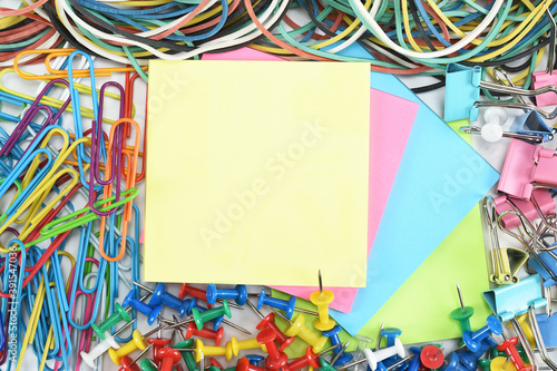 Stickers for notes, buttons, paper clips, money bands and clothespins laid out on the desktop