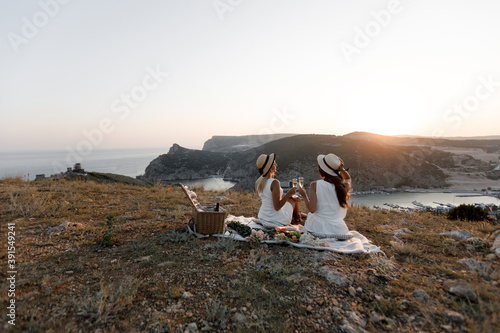 Two beautiful happy young friends on a picnic. The concept of communication, vacation, tourism