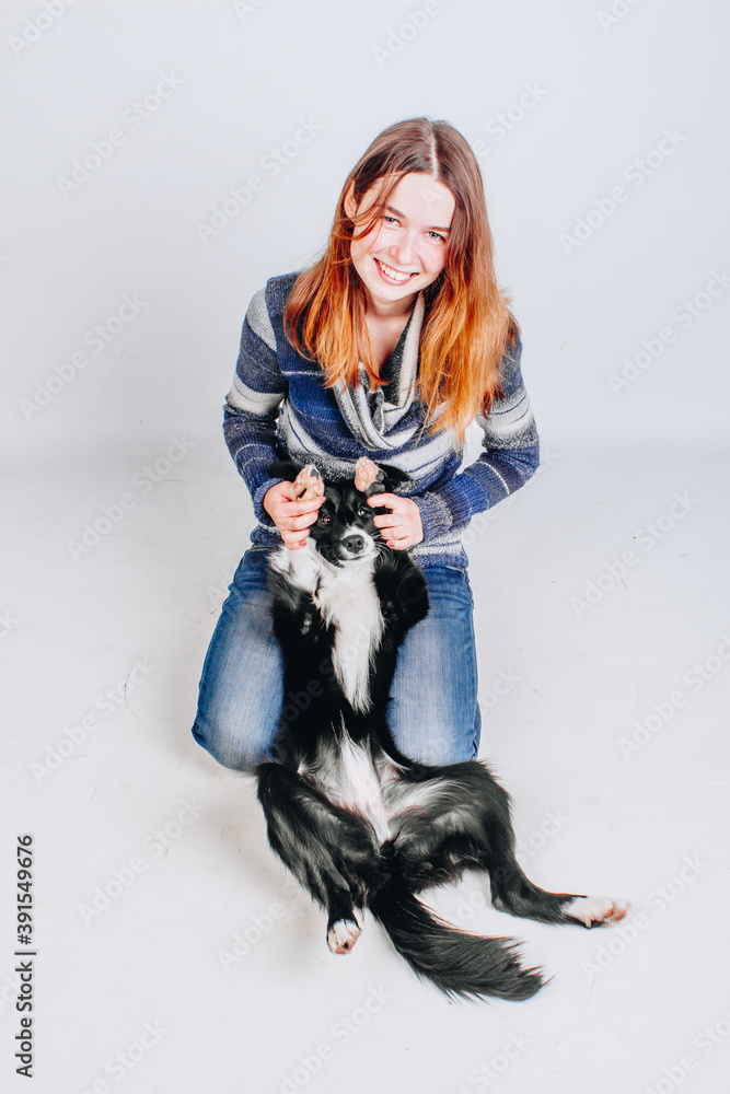 Border collie dog is happy and is resting with her owner. Woman with her puppy. Owner and a pet. Dog lying and playing with a girl, they're friends. Border collie dog is happy and is resting with her owner. Woman with her puppy. Owner and a pet. Dog lying and playing with a girl, they're friends.