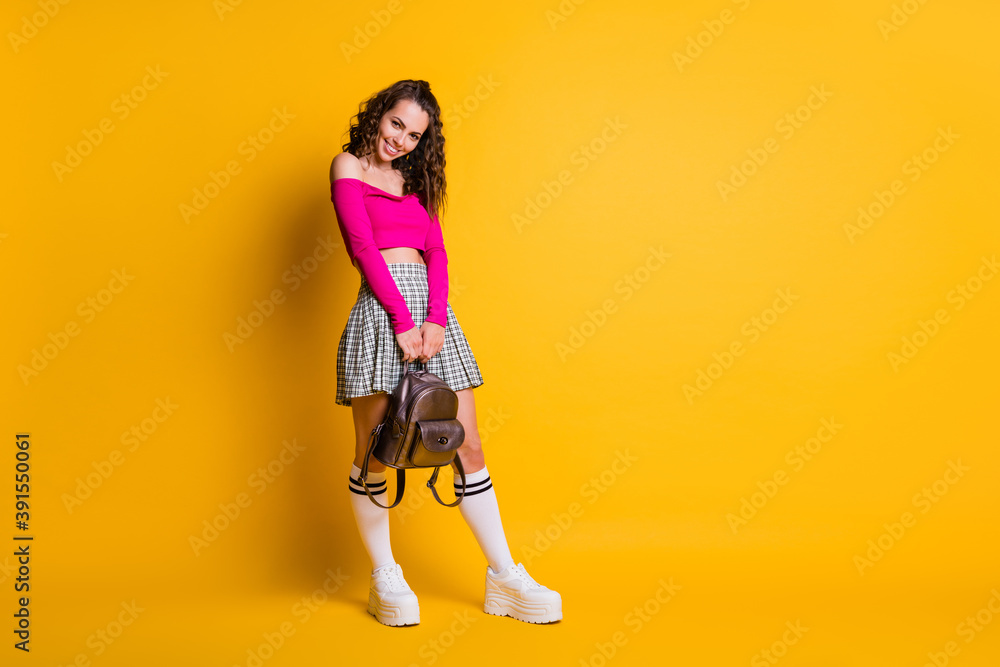 Full length photo of lady wavy hairdo toothy smile hold backpack wear pink top unclothed shoulders mini skirt white stockings sneakers isolated yellow color background Full length photo of lady wavy hairdo toothy smile hold backpack wear pink top unclothed shoulders mini skirt white stockings sneakers isolated yellow color background
