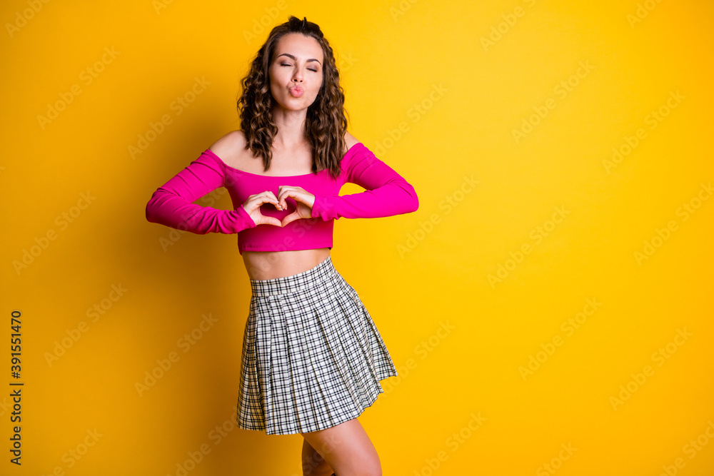 Photo portrait full body view pretty girl sending air kiss showing heart with hands with closed eyes for valentine's day wearing short skirt pink top isolated vivid yellow colored background Photo portrait full body view pretty girl sending air kiss showing heart with hands with closed eyes for valentine's day wearing short skirt pink top isolated vivid yellow colored background