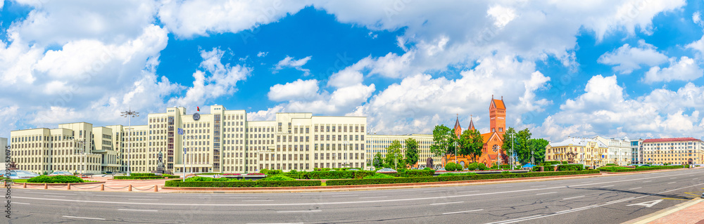 Panorama of Independence Square in Minsk city centre with Government House and Saints Simon and Helena Roman Catholic church or Red Church, blue sky in sunny summer day, Republic of Belarus