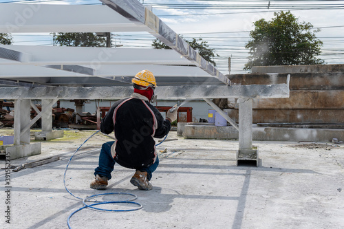 Fotografi The painter is working to fireproof paint on steel structure with spray gun, at industrial factory